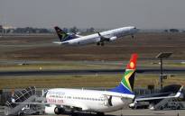 A South African airways flight takes off as another one is parked in a bay on the tarmac on 25 May, 2010 at the Johannesburg O.R Tambo International airport in Johannesburg, South Africa. Picture: AFP