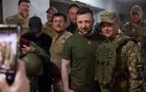This handout picture taken and released by the press service of the Ukrainian Presidency on 18 June, 2022 shows Ukrainian President Volodymyr Zelensky (2ndR) posing for the picture with a servicewoman during his visit to the position of Ukrainian troops in Mykolaiv region. Picture: Handout / UKRAINE PRESIDENCY / AFP