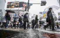 People use their umbrellas to shelter from the rain as they walk through Shibuya district in Tokyo on 2 June 2023. Picture: Yuichi YAMAZAKI/AFP