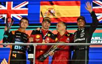 Ferrari's Spanish driver Carlos Sainz Jr (2nd L) celebrates on the podium with Ferrari team principal Frederic Vasseur (2nd R) after winning the Singapore Formula One Grand Prix night race, with McLaren's British driver Lando Norris (L) who finished second and Mercedes' British driver Lewis Hamilton who finished third (R), at the Marina Bay Street Circuit in Singapore on 17 September 2023. Picture: Lillian SUWANRUMPHA/AFP
