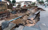 A general view of a severely damaged home and a crack in the road following heavy rains and winds in Durban, on 12 April 2022. Picture: RAJESH JANTILAL/AFP
