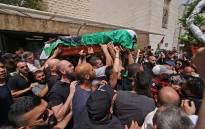 Palestinian mourners carry the casket of slain Al-Jazeera journalist Shireen Abu Akle out of a hospital, before being transported to a church and then her resting place, in Jerusalem, on May 13, 2022. Picture: Ahmad Gharabli / AFP.