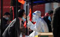 FILE: A medical worker takes a sample from a resident to be tested for the COVID-19 coronavirus in Xi'an, in China's northern Shaanxi province on 21 December 2021, after the detection of more than 40 new cases raised concerns of wider transmission ahead of a busy travel season. Picture: STR/AFP