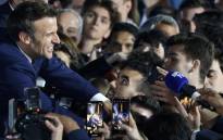 French President and La Republique en Marche (LREM) party candidate for re-election Emmanuel Macron (L) greets supporters after his victory in France's presidential election, at the Champ de Mars in Paris, on April 24, 2022. Picture: Ludovic Marin / AFP