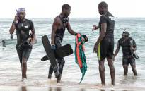 Senegalese rescue personnel pull clothing items belonging to one of the victims from the ocean in Ouakam, in Dakar on 24 July 2023 after a boat capsized off the coast of Dakar. At least 14 people died after their wooden boat capsized off the Senegalese capital Dakar, a district deputy mayor told AFP on 24 July 2023. Picture: SEYLLOU/AFP