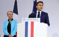 France's President Emmanuel Macron (R) addresses a speech next to France's Prime Minister Elisabeth Borne (L) at the Defense Minister's residence, Hotel de Brienne, for a reception for military staff on the eve of Bastille Day, in Paris, France, on 13 July 2023. Picture: Teresa SUAREZ/POOL/AFP
