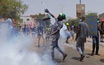 An anti-coup protester throws back a tear gas canister at security forces during clashes amdist mass demonstrations against military rule in the centre of Sudan's capital Khartoum on 30 June 2022. Picture: AFP