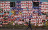 A man walks next to campaign posters of various candidates pasted on the walls, in Nairobi, on 2 August 2022, ahead of Kenya's August 2022 general election. Picture: Simon MAINA/AFP