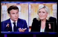 A picture shows a TV screen displaying a live televised between French President and La Republique en Marche (LREM) party candidate for re-election Emmanuel Macron (L) and French far-right party Rassemblement National (RN) presidential candidate Marine Le Pen (R), broadcasted on French TV channels TF1 and France 2, in Saint-Denis, north of Paris, ahead of the second round of France's presidential election. Picture: Ludovic Marin / AFP