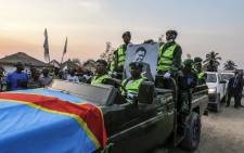 Military personnel hold a portrait of slain Congolese independence leader Patrice Lumumba as they ride in a convoy with his coffin after its arrival at Tshumbe in DR Congo on June 22, 2022. Picture: Junior KANNAH / AFP