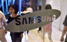 People walk past the logo of Samsung Electronics at the company’s headquarters in Seoul on 30 July 2015. Picture: AFP.