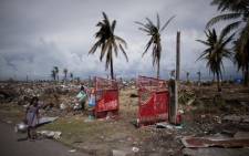 A typhoon victim walks past land ravaged by Typhoon Haiyan in Tacloban, Philippines on November 13, 2013. Picture: AFP.