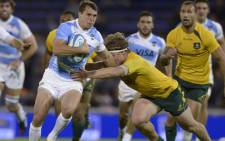 Argentina’s wing Juan Imhoff (L) runs through a tackle by Australia’s flanker Michael Hooper during the Rugby Championship sixth round match at Gigante de Arroyito stadium in Rosario, 5 October, 2013. Picture: AFP.