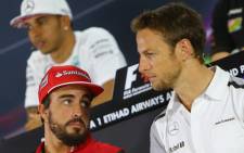 Ferraris Spanish driver Fernando Alonso (L) chats with McLaren Mercedes' British driver Jenson Button (R) as Mercedes-AMG's British driver Lewis Hamilton looks on during the press conference at the Yas Marina circuit in Abu Dhabi on November 20, 2014 ahead of the Abu Dhabi Formula One Grand Prix. Picture: AFP