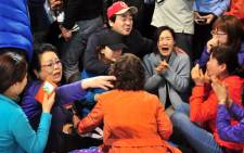 South Korean relatives of passengers on board a capsized ferry cry as they wait for news about their loved ones, at a gym in Jindo on 17 April, 2014. Picture: AFP.