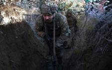 Ukrainian Territorial Defense Forces walk on a trench on the frontline with Russia-backed separatists near to Avdiivka, Ukraine on 8 January 2022. Picture: AFP
