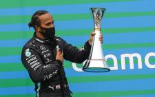 Mercedes' British driver Lewis Hamilton celebrates with the trophy on the podium of the Formula One Hungarian Grand Prix race at the Hungaroring circuit in Mogyorod near Budapest, Hungary, on 19 July 2020. Picture: AFP