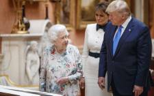 Britain's Queen Elizabeth II (L), US President Donald Trump (R) and US First Lady Melania Trump (C) view displays of US items of the Royal collection at Buckingham Palace in central London on 3 June 2019, on the first day of their three-day state visit to the UK. Picture: AFP.