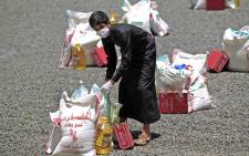 A Yemeni youth carries a portion of food aid, distributed by Yadon Tabney development foundation, in Yemen's capital Sanaa on 17 May 2020. Picture: AFP.