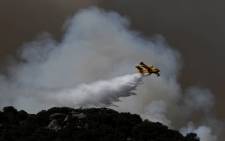 A Canadair drops water over a wildfire in the outskirts of Cenicientos in central Spain on 29 June 2019. Spain was hit by more wildfires as temperatures remained sky-high in the Europe-wide heatwave, authorities said, just as firefighters finally managed to contain another blaze they had been tackling for nearly 72 hours. Picture: AFP