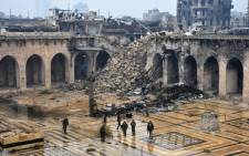 A general view shows Syrian pro-government forces walking in the ancient Umayyad mosque in the old city of Aleppo on 13 December 2016. Picture: AFP 