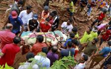 Rescue workers shift a body from the debris left after a landslide at Kavalappara in Malappuram district of the south Indian state of Kerala on 11 August 2019. Picture: AFP