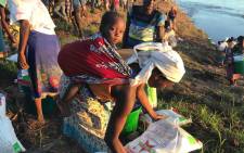 A mother gathers her food and water she received from the relief workers after Cyclone Idai hit Mozambique. Picture: Christa Eybers/EWN