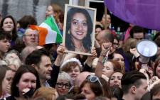 People hold up a portrait of Savita Halappanavar, the Indian dentist who died in Galway because of complications of a miscarriage, at Dublin Castle in Dublin on 26 May, 2018 as they celebrate the referendum decision in favour of repealing the constitutional ban on abortions. Picture: AFP.