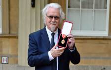 FILE: British comedian Billy Connolly poses with his medal after being knighted as a Knights Bachelor (knighthood) for services to entertainment and charity during an investiture ceremony at Buckingham Palace, London on 31 October 2017. Picture: AFP