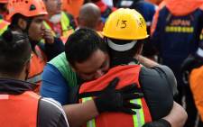 Rescue workers embrace each other after a seismic alert sounded in Mexico City on 23 September 2017, four days after the powerful quake that hit central Mexico. Picture: AFP.
