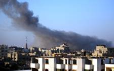 FILE: Smoke billows from buildings following an Israeli air strike in Gaza City early on 10 July 2014. Picture: AFP.