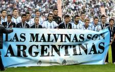 Argentina's footballers hold a banner reading "The Malvinas / Falkland Islands are Argentine" before a friendly football match against Slovenia at La Plata stadium, Buenos Aires, Argentina, 7 June 2014. Picture: AFP.