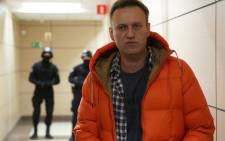 FILE: Russian opposition leader Alexei Navalny stands near law enforcement agents in a hallway of a business centre, which houses the office of his Anti-Corruption Foundation (FBK), in Moscow on 26 December 2019. Picture: AFP