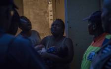 A woman and her family protest their arrest after returning to her room in a hijacked building where she was previously evicted. Picture: Thomas Holder/EWN