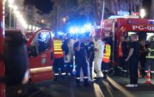 FILE: Police officers, firefighters and rescue workers are seen at the site of an attack on the Promenade des Anglais on July 15, 2016, after a truck drove into a crowd watching a fireworks display in the French Riviera town of Nice. Picture: AFP.
