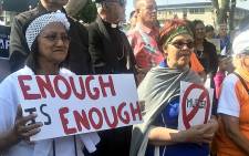 People hold up posters during a demonstration against gender-based violence in Parow, Cape Town, on 15 September 2019. Picture: Shamiela Fisher/EWN.