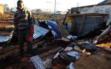A man stands beside the ruins of a shack after a Tornado struck Tembisa on Tuesday 26 July 2016. Picture: Masego Rahlaga/EWN.