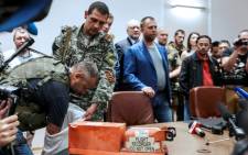 A pro-Russia separatist shows members of the media a black box belonging to Malaysia Airlines flight MH17, before handing it over to Malaysian representatives during a press conference in Donetsk on 22 July 2014. Picture: AFP.