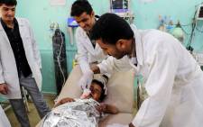Medics treat a Yemeni child who was injured in a reported air strike at an emergency clinic in the Iran-backed Huthi rebels' stronghold province of Saada on 8 August 2018. Picture: AFP
