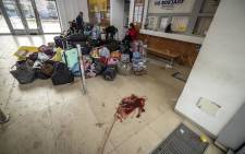 Evacuees sit near luggage in the train station hall in Kramatorsk, eastern Ukraine on 8 April 2022 after a rocket attack. 