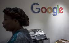 A worker of the Google Artificial Intelligence (AI) centre walks through a Google sign inside the office in Accra on 10 April 2019. This centre is the first AI centre established in Africa by Google. Picture: AFP