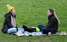 People sit on the grass together chatting in Battersea Park in London on March 28, 2021. From Monday, England's stay-at-home order to combat the spread of the coronavirus will be relaxed to enable groups of up to six people to meet outside. The government plans to allow outdoors drinking in pub gardens, and non-essential retail such as hairdressers, from April 12. Picture: Justin Tallis / AFP.