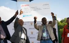President Jacob Zuma hands over a cheque to the leader of the Mahishi community as part of the first phase of compensation in the land claim agreement.  Picture: Christa Eybers/EWN.