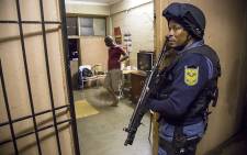 After a search, police move out of a room where a couple are living in Alexander during the overnight raid on 22 April 2015. Picture: Thomas Holder/EWN.