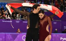 Canada's Scott Moir kisses Canada's Tessa Virtue while holding the Canada flag after they won the gold during the free dance of the figure skating event during the Pyeongchang 2018 Winter Olympic Games on February 20, 2018. Picture: AFP
