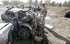 An Iraqi soldier inspects the site of a car blast. Picture: AFP.
