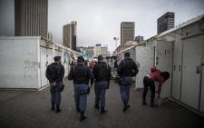 Saps officers patrol the station deck in Cape Town during an operation in the CBD. Picture: Thomas Holder/EWN