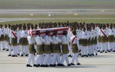 Soldiers carry a coffin with the remains of a Malaysian victim from the Malaysia Airlines flight MH17 that crashed in Ukraine during a ceremony at the Bunga Raya complex at Kuala Lumpur International Airport in Sepang on 22 August, 2014. Picture: AFP.