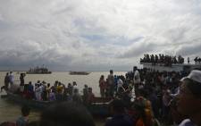FILE:Bangladeshi onlookers gather near the scene where an overloaded ferry capsized in the Padma river in Munshiganj, some 30 km south of the capital Dhaka, on 4 August 2014. Picture: AFP.