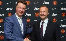 Manchester United coach Louis van Gaal (L) and Chief Executive Ed Woodward shake hands at van Gaal's official unveiling as coach. Picture: Official Manchester United Facebook Page